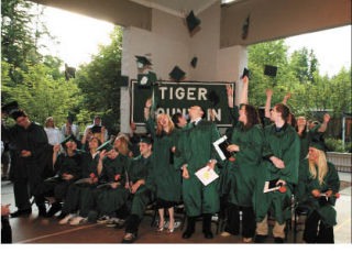 Tiger Mountain graduates throw off their caps in celebration.