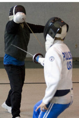 Kevin Mar and student Lauren Poulson demonstrate a counterattack technique in front of the class.