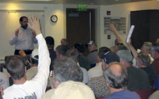 Several members of the audience raise their hands to ask questions about the proposed closure of Tokul Creek Fish Hatchery during a meeting on Sept. 10.