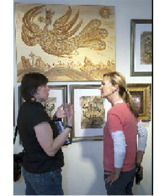 Katya Palladina (left) talks with Janelle Davidson in front of Palladina’s ‘Golden Flight’ painting Aug. 1 at Upfront Gallery in Issaquah. Palladina will display some of her mixed-media paintings Oct. 11 and 12 at the Sammamish Art Fair. The art fair runs 10 a.m. to 5 p.m. both days at the Sammamish City Hall
