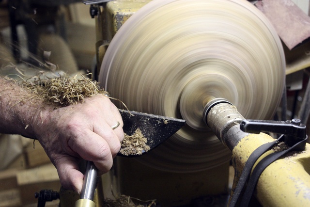 Steve Sergey carves a wood piece using his lathe at home.