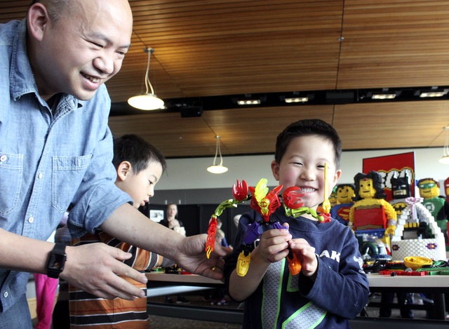 Megan Campbell/staff photoHang Zhang helps his 4-year-old son