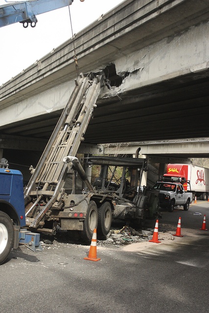 Daniel Nash/staff photoA Recology Cleanscapes truck punches a hole in the Interstate-90 Front Street overpass’s southern side in March 2015.