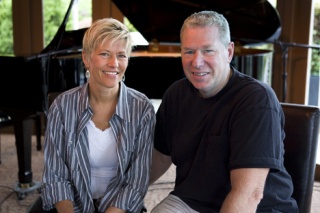 Laura and Craig Baker sit near the grand piano on the stage at Bake's Place.