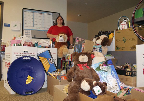 Detective Amy Jarboe of the Woodinville Police Department stands with the collection of Toys for Tots donations in the Sammamish Police Department Friday.