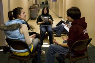 Briana Bywaters and Alex Darling rehearse their lines as Abigail Johnson checks the script.