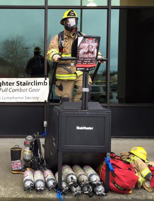 Eastside Fire and Rescue firefighters demonstrate climbing stairs in full gear on a stair machine in front of the Sammamish Safeway Feb. 13. They will be fundraising in Issaquah Feb. 20 before heading to the “Climb for the Cure” competition March 6.