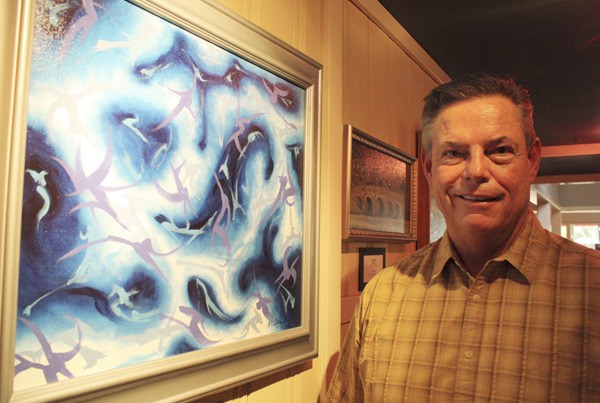 Sammamish artist Bill Proby stands in a hallway at the Issaquah Pogacha restaurant where several of his pieces are on display.