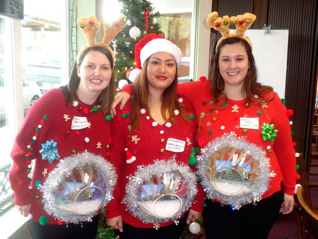 Megan Matuszewski, Cameryn Mirafuentes and Rachel Arata of the Springhill Suites Marriott won the prize for having the ugliest festive sweaters. They said that they made their snowglobe costumes themselves in only a couple of hours. Nicole Jennings/staff photo