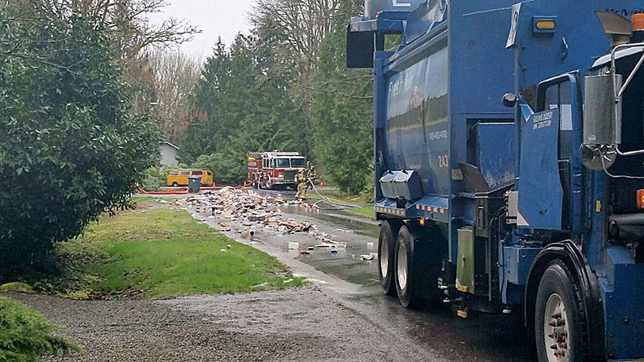 Recycling truck dumps haul of materials after fire breaks out in rear of vehicle