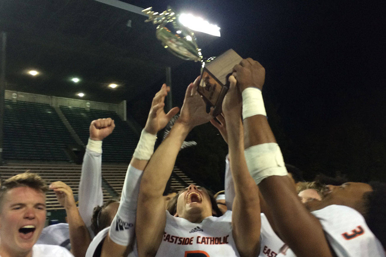 Shaun Scott, staff photo                                The Eastside Catholic Crusaders football team hoists the Metro League championship trophy following their 49-6 victory against the Roosevelt Roughriders on Oct. 20 at Memorial Stadium in Seattle. The Crusaders finished the 2017 regular season with an overall record of 8-0.
