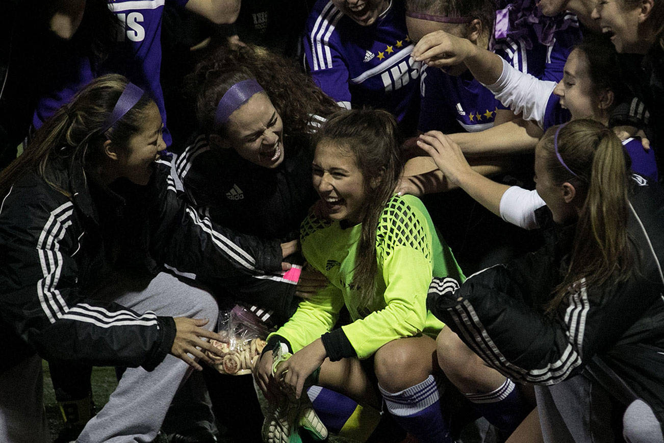 Photo courtesy of Don Borin/Stop Action Photography                                Issaquah Eagles players surround goalie Chloe Lang (yellow jersey) after she made two dramatic saves in a penalty kick shootout against the Puyallup Vikings. The Eagles outscored the Vikings 3-2 in the overtime shootout to capture a victory in the first round of the Class 4A state playoffs.