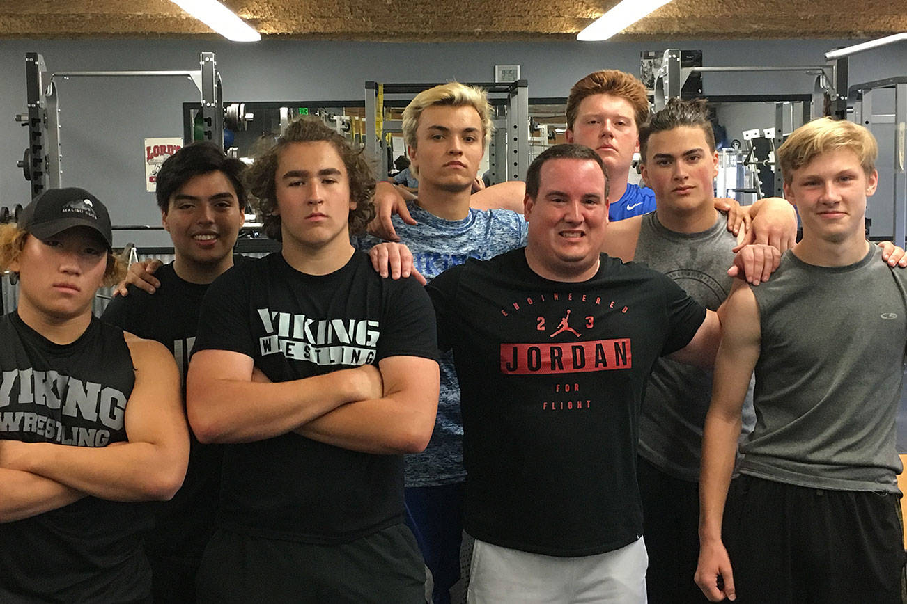 Sound Publishing sportswriter Shaun Scott poses for a quick picture with members of the Bellevue Christian Vikings football team following a weight training session on July 19 at Bellevue Christian School in Bellevue. Photo courtesy of Todd Green