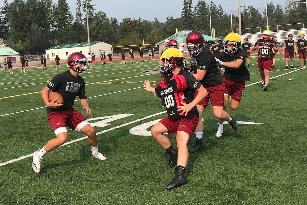 Eastlake Wolves quarterback Jackson Proctor, left, scrambles for extra yardage during the second day of practice on Aug. 16 in Sammamish. Shaun Scott/staff photo