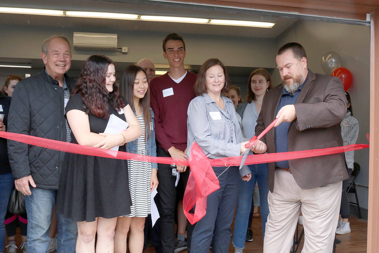 Director KayLee Jaech and Issaquah City Council member Tola Marts cut the ribbon at the grand opening of The Garage teen cafe. Evan Pappas/Staff Photo