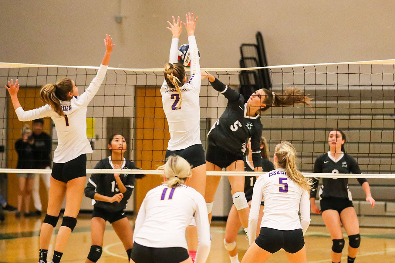 The Issaquah Eagles cruised to a 3-0 victory against the Skyline Spartans in a rivalry matchup on the volleyball court on Oct. 3 in Sammamish. Issaquah junior Maya Patton, (No. 2), leaps into the air for the block at the net against Skyline. The Eagles improved their overall record to 7-1 with the victory. Photo courtesy of Rick Edelman/Rick Edelman Photography