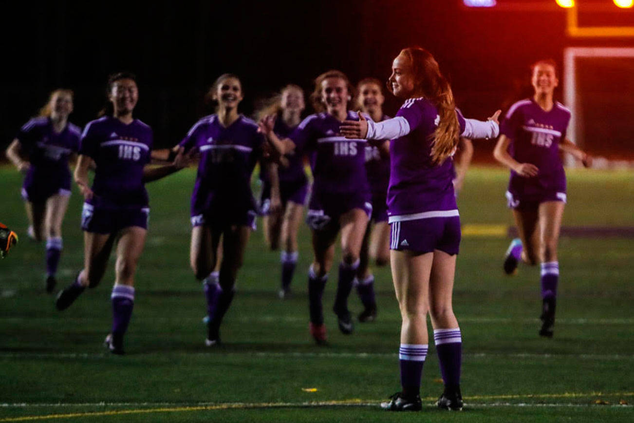 Issaquah Eagles girls soccer players make a beeline for Riley Larsen, who is standing with her arms outstretched, after she hit the game clinching penalty kick in the overtime shootout on Nov. 1 at Gary Moore Stadium in Issaquah. Photo courtesy of Don Borin/Stop Action Photography