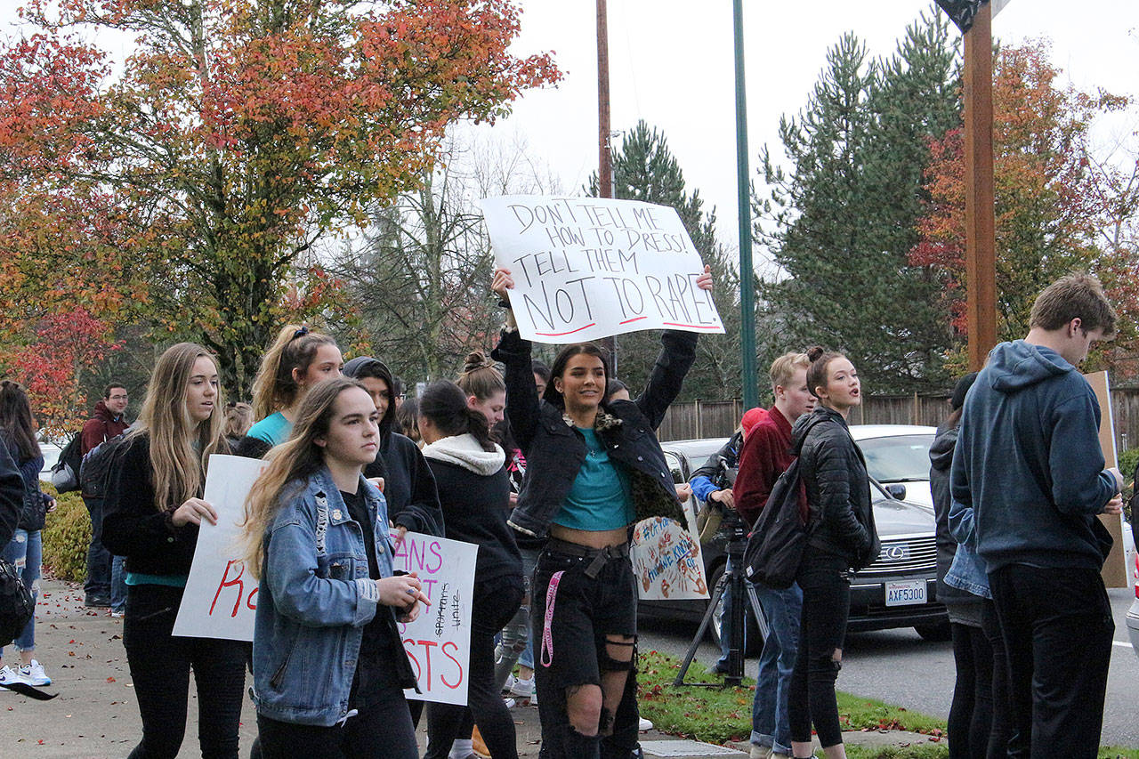 Skyline High School students and community members protest perpetuation of rape culture following a lawsuit aginst the Issaquah School District. Left: Chloe Strandwold, senior and organizer of protest; center: Amelia Danyuk, senior, holds sign saying “Don’t Tell Me How to Dress! Tell Them Not to Rape.” Madison Miller/staff photo.