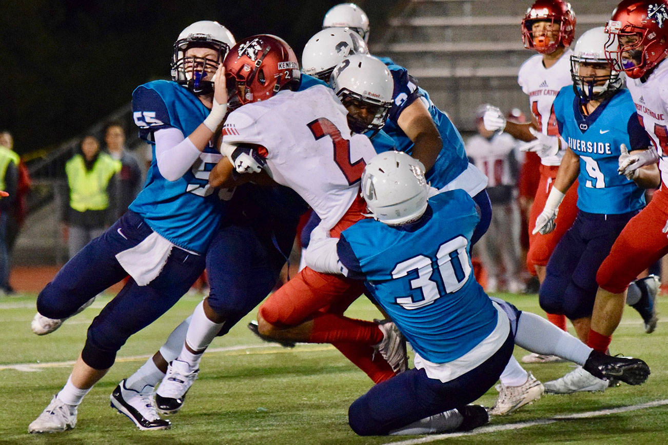Auburn Riverside defenders bring down Kennedy Catholic’s Junior Alexander during North Puget Sound League Mountain Division action in Oct. 2018 at Auburn Memorial Stadium. Photo by Rachel Ciampi/Auburn Reporter