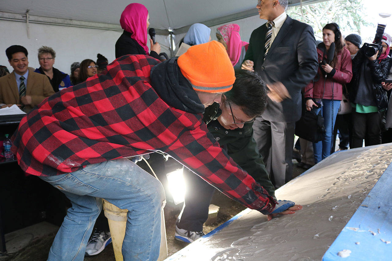 Redmond Mayor John Marchione was among many community members to place their hand prints in the wet cement below the new sign at the Muslim Association of Puget Sound in Redmond after the mosque’s old sign was vandalized in 2016. File photo
