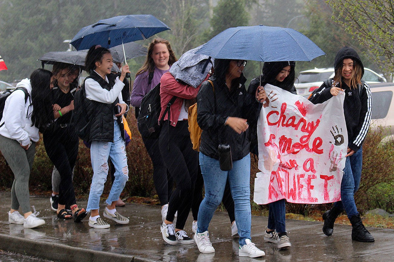IHS students walkout to protest racist post on Wednesday with a sign that says “Change is More Than a ReTweet.” Madison Miller / staff photo