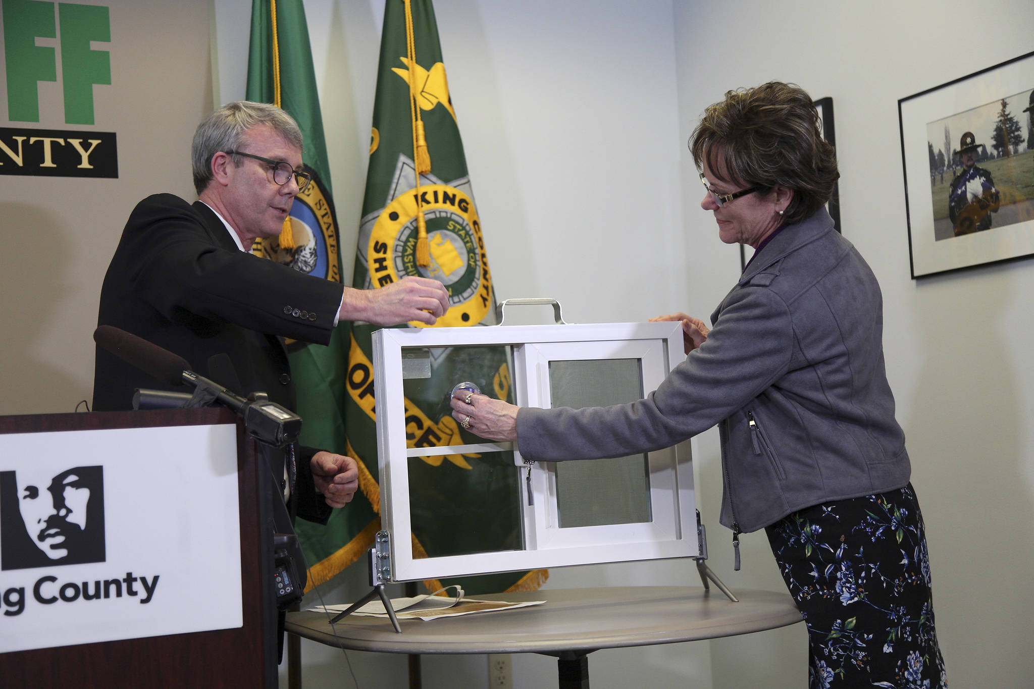 Dr. Brian Johnston, Chief of Pediatrics at Harborview Medical Center, and Councilmember Kathy Lamber give a demonstration with a window safety device. Ashley Hiruko/staff photo