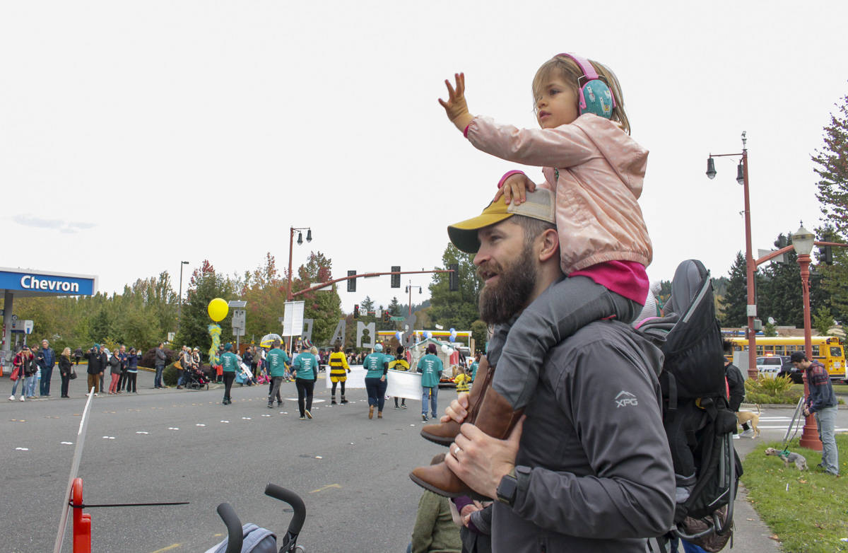 Natalie DeFord/staff photo                                3-year-old Sylvie watches the Salmon Days Oct. 5 Grande Parade from atop Corey Derr’s shoulders, waving at all the princesses.