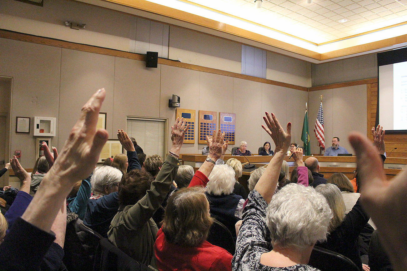 Madison Miller/staff photo                                Providence Point residents raise hands in support of a Providence Point speaker at the Jan. 21 city council meeting.