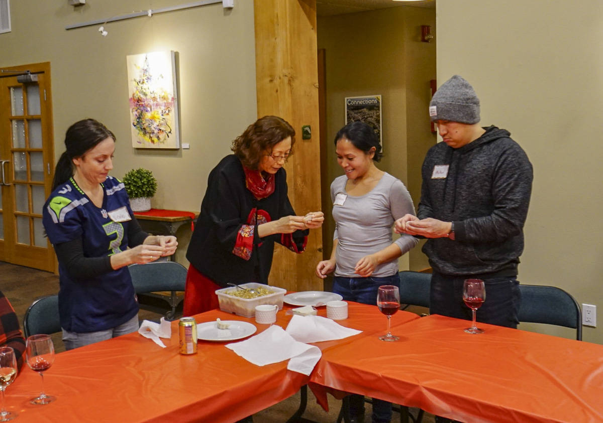 From left: Nicole Ardres, volunteer Wei Geiger, Christine Callo and Michael Eng at a Issaquah Highlands Lunar New Year event. At this Jan. 17 dumpling making workshop, Geiger demonstrated how to fill Chinese dumplings. Courtesy photo by Yuan Yuan Lin.
