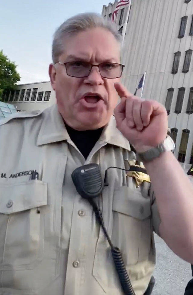 A sheriff’s court marshal confronts someone recording the doughnut incident. (Screen grab from video courtesy of Bennett Haselton)