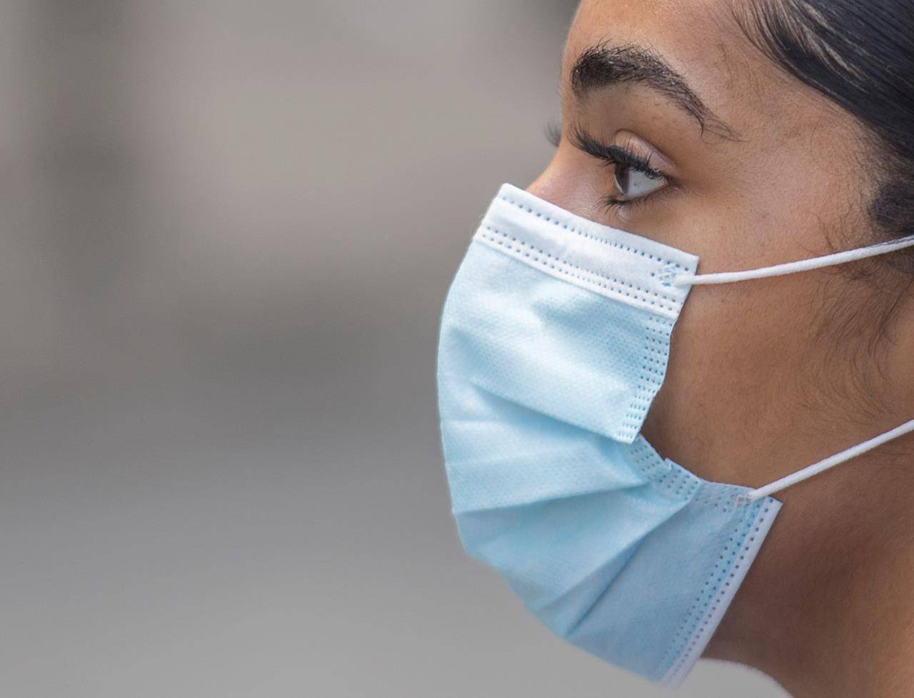 A person wears a face mask on a street in Montreal, Saturday, Aug. 22, 2020. THE CANADIAN PRESS/Graham Hughes