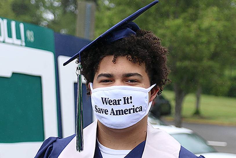In this file photo, Tayshon Cottrell dons his graduation cap and gown, along with a face mask reading: “Wear it! Save America” at Todd Beamer High School’s virtual graduation walk recording on May 20, 2020, in Federal Way. Olivia Sullivan/Sound Publishing