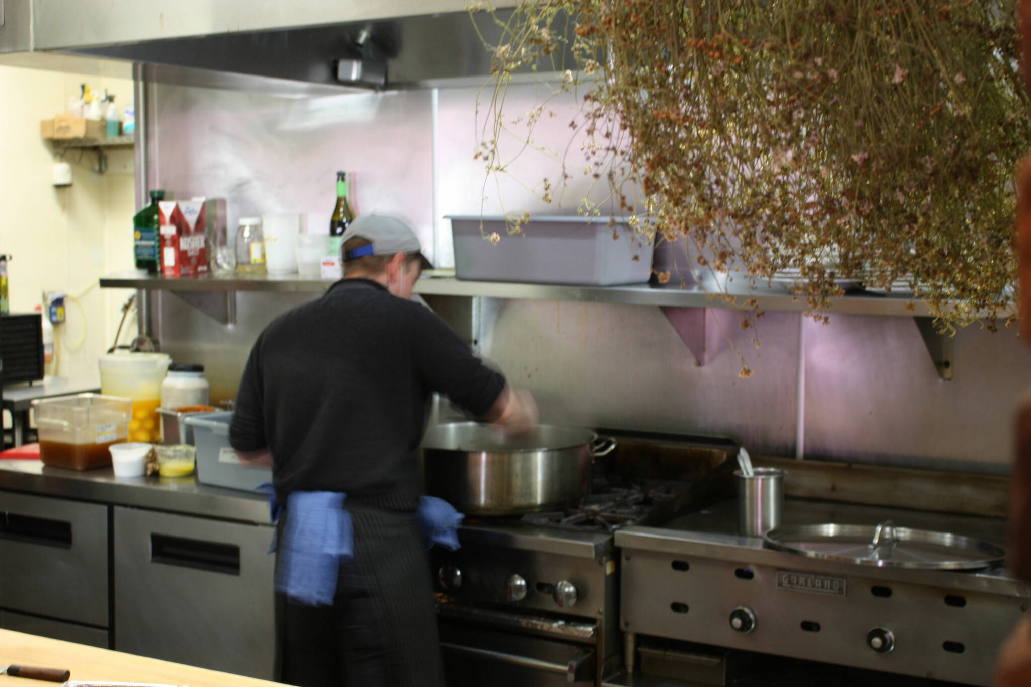 Chef Kyle Bopes working in the kitchen at The Grange. Herbs hang to dry. Photo by Cameron Sheppard/Sound Publishing