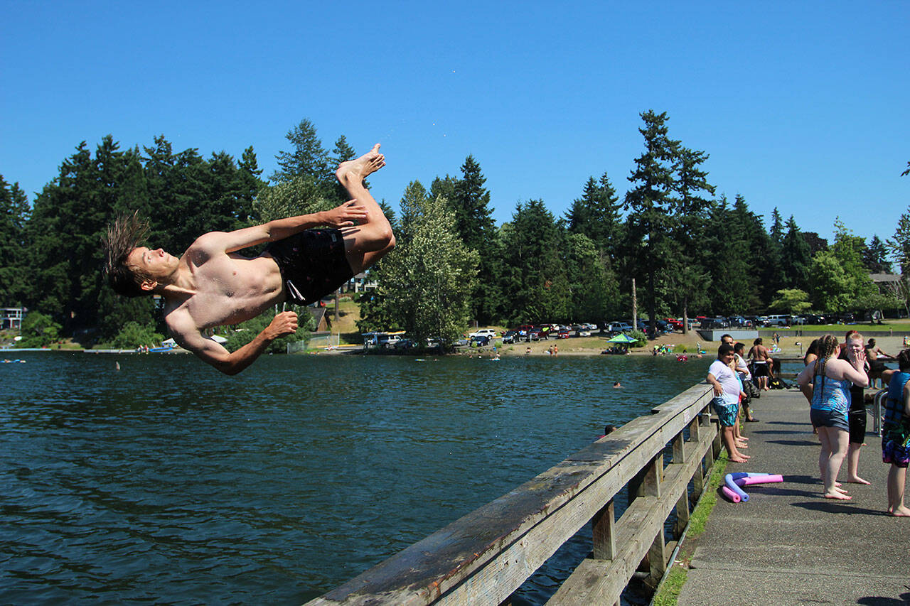 Fedor Osipov, 15, flips into Steel Lake in Federal Way during last year's heatwave on June 28, 2021. Olivia Sullivan/Sound Publishing