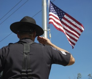 Sammamish Police Sgt. Pete Horvath salutes as the American flag is flown at half mast to honor Lewis County Sheriff's Office Deputy Mike Gallagher