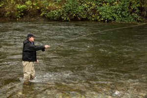 Bruce Farr casts his line in the Cedar River to demonstrate fly fishing technique.