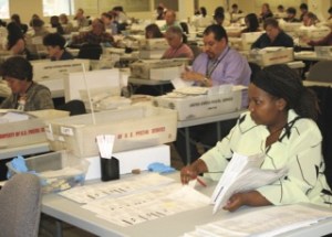Election worker Regina Ngoya Tuesday inspects ballots for such issues as voter-corrected errors before the ballots are sent on for counting.