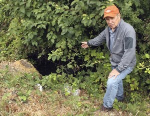 Sammamish resident Wally Pereyra stands next to the city-owned culvert under East Lake Sammamish Parkway