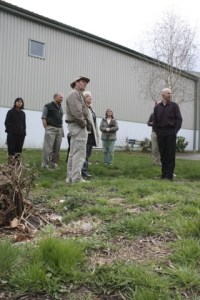 AtWork! staff member Jed Vassallo (right) gives community members a tour of the property donated for the community garden project.