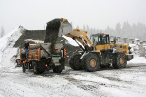 A tractor fills a dump truck