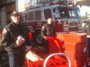 Firefighters load food donations into bins as part of this weekend's 4th Annual Fill-The-Truck Food and Clothing Drive.