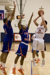 Eastside Catholic’s Darin Nakatsu fades away for a shot over Rainier Beach’s Corey Stern (11) and Jamon Echols (5).