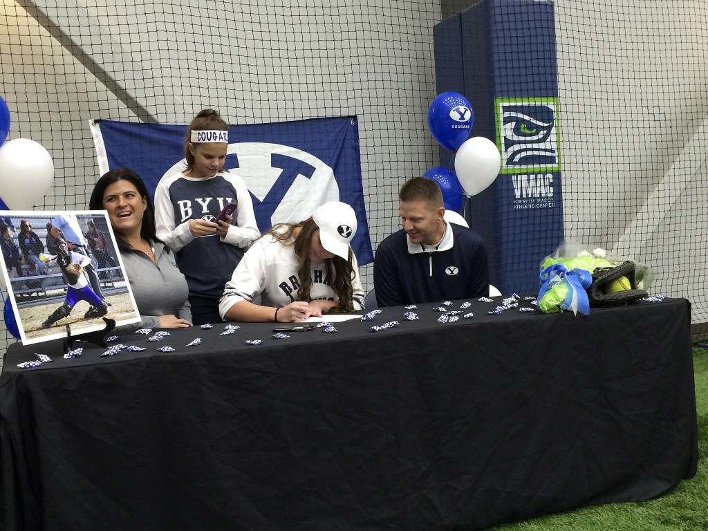 Issaquah Eagles senior Morgan Bevell, center, signs a letter of intent to play softball at Brigham Young University on Nov. 14 at the Virginia Mason Athletic Center in Renton.                                Shaun Scott, staff photo