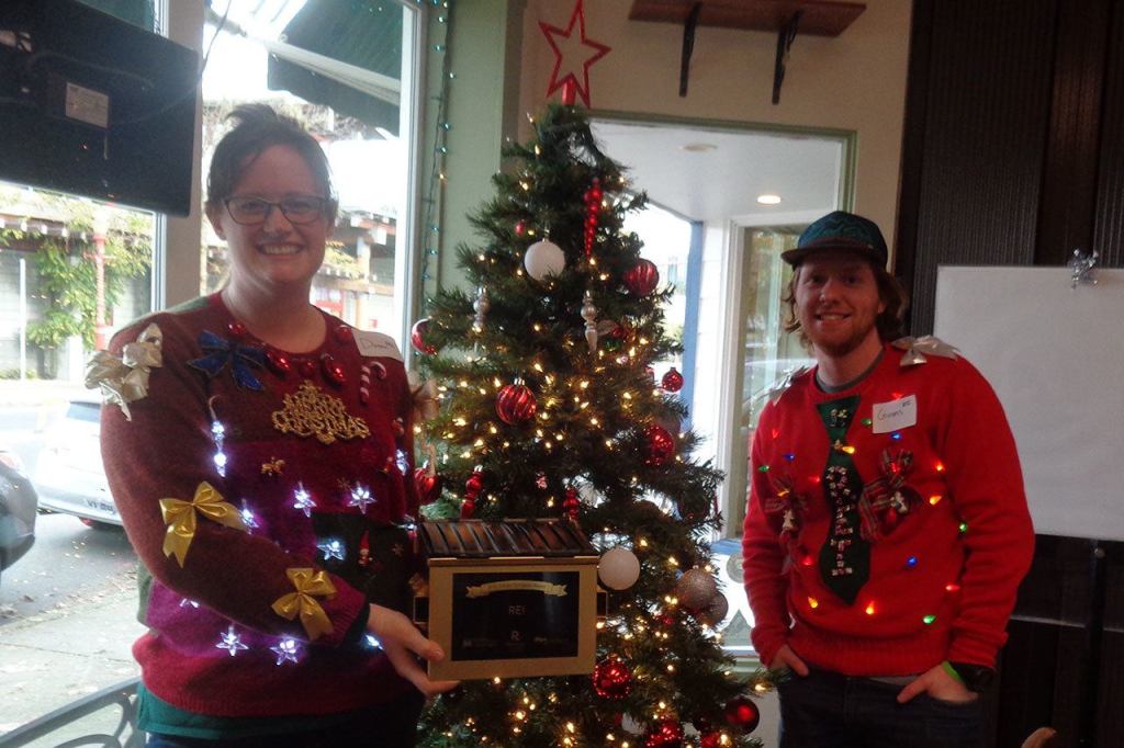 REI Golden Dumpster winners Donna Androwski and Guiness Ayers are nearly brighter than the Christmas tree in their festive sweaters. Nicole Jennings/staff photo