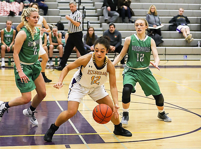 Issaquah Eagles junior Maya Witherspoon, center, controls the ball as Woodinville players Madison Dubois and Nikki Zaback converge on her. The Falcons defeated the Eagles 61-43 on Dec. 12 at Issaquah High School.                                Photo courtesy of Rick Edelman/Rick Edelman Photography