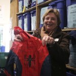 Helen Banks Routon, director of development and community relations, holds up a Spiderman jacket that will go out to a young boy in need. Nicole Jennings/staff photo