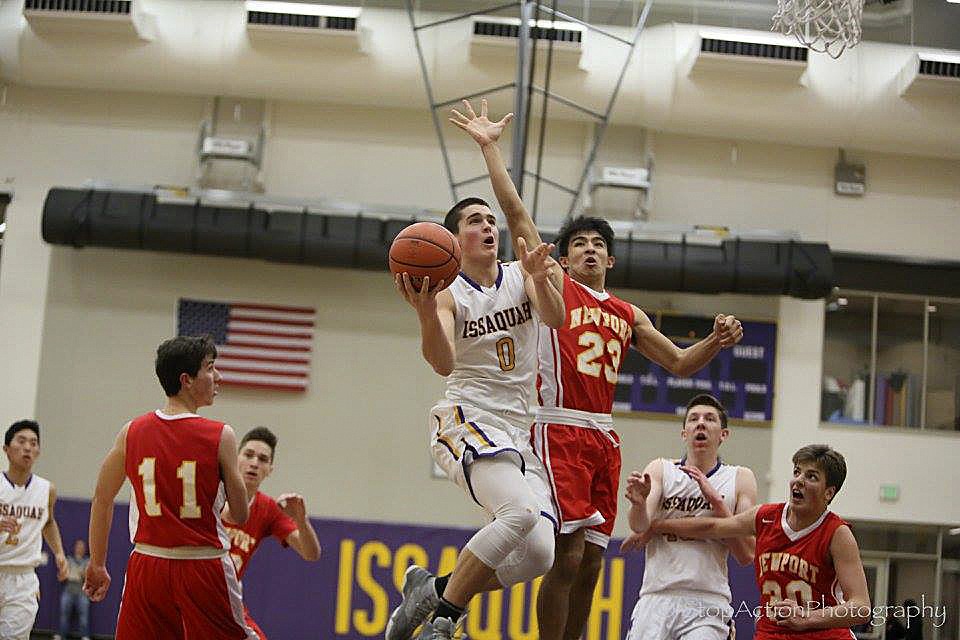 Photo courtesy of Don Borin/Stop Action Photography                                Issaquah senior Tanner Davis, left, takes the ball strong to the basket while being chased by Newport junior Marcus Fukutomi, right, on Jan. 13 at Issaquah High School.