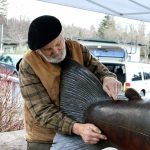 Artist Tom Jay shows the area that was cut by the vandal, demonstrating with his hands how long the cut stretched. Nicole Jennings/staff photo