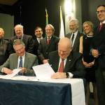 Sammamish City Council members share a laugh as Central Washington University President Dr. James Gaudino, seated right, signs a lease agreement with City Manager Lyman Howard Tuesday night at Sammamish City Hall. The university will occupy the former Mars Hill property in Sammamish, with classes expected to begin this fall (Joe Livarchik/staff photo).