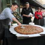 Metropolitan Market President and CEO Todd Korman cuts into a 3-foot fresh-baked cookie during a &ldquo;cooking-breaking&rdquo; ceremony to celebrate the opening of Metropolitan Market in Sammamish on Wednesday morning (Joe Livarchik/staff photo).
